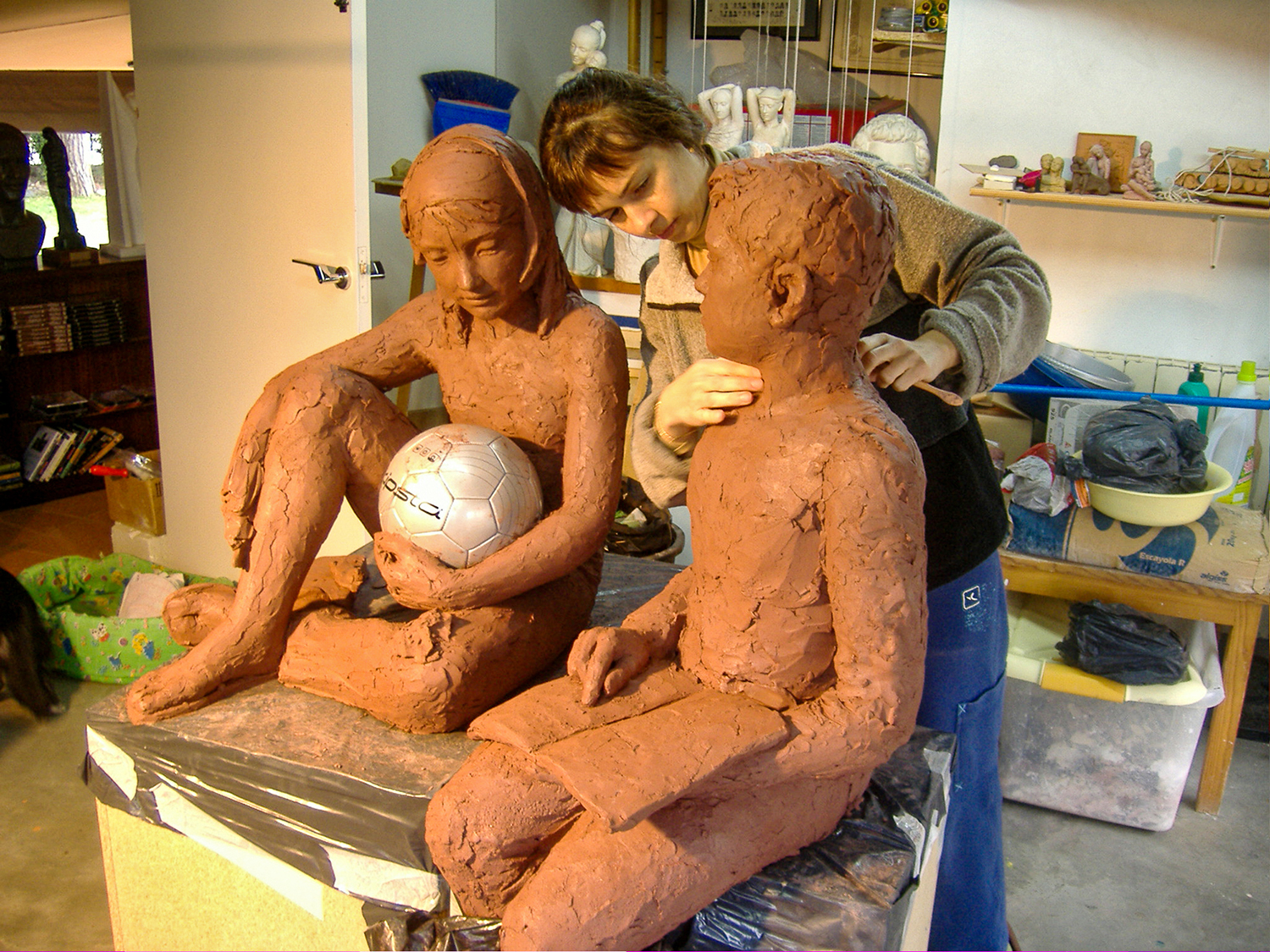Ció modelant l'escultura en argila