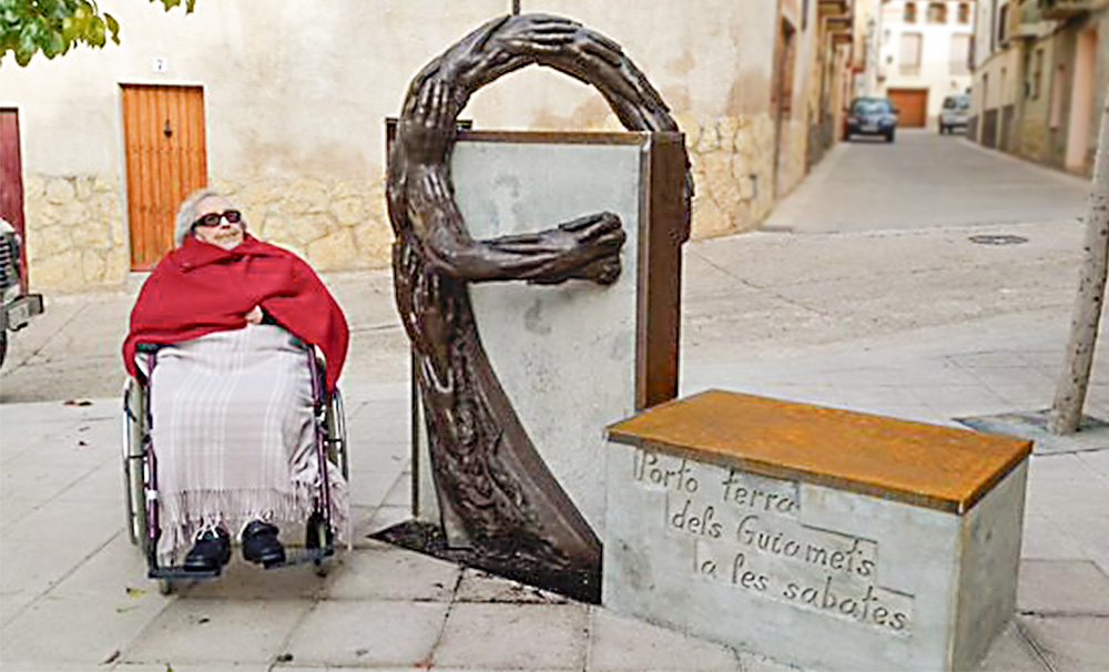 Neus Català davant l'escultura del seu homenatge